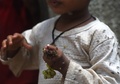 パキスタン・カラチのスラム街で、ハエが群がる中でブドウを食べる子ども（2019年9月2日撮影）。(c)ASIF HASSAN / AFP