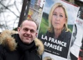 仏エナンボーモンで、国民戦線（FN）のマリーヌ・ルペン党首の写真を使った選挙ポスターを背景に立つスティーブ・ブリオワ町長（2017年1月30日撮影）。(c)AFP/FRANCOIS LO PRESTI