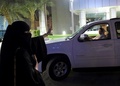サウジアラビアのリヤドで、午前0時を過ぎ女性の車の運転が解禁されたことを受け、始めて車で道路に出た女性の運転手に勝利のVサインをする女性（2018年6月24日撮影）。(c)AFP/FAYEZ NURELDINE