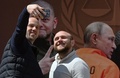 ウクライナの首都キーウに登場した、国際刑事裁判所の法廷に立つロシアのウラジーミル・プーチン大統領を描いたパネルの前で自撮りする男性（2023年5月11日撮影）。(c)Sergei SUPINSKY / AFP