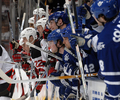 写真は、デビルズのキャム・ヤンセン（%%Cam Janssen%%）とメープルリーフスのウェイド・ビーラク（%%Wade Belak%%）の乱闘を見守る両チームの選手達。(c)AFP/Getty Images Dave Abel