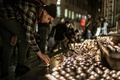 仏リヨンの市庁舎に面したテロー広場で、パリで発生した連続襲撃事件の犠牲者を追悼するため、キャンドルに火をともす男性（2015年11月14日撮影）。(c)AFP/JEFF PACHOUD