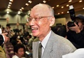 ノーベル医学生理学賞の受賞が決まったことを受けて東京都内の北里大学で開かれた記者会見の会場で、学生らからお祝いの言葉を掛けられて笑顔を見せる大村智・北里大特別栄誉教授（2015年10月5日撮影）。(c)AFP/Yoshikazu TSUNO