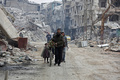 シリアの首都ダマスカス近郊の東グータで、反体制派が撤退した後のハラスタの町を歩く民間人ら（2018年3月30日撮影）。(c) AFP PHOTO