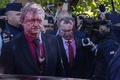 ポーランド・ワルシャワの旧ソ連兵墓地で赤い液体を掛けられたセルゲイ・アンドレーエフ駐ポーランド・ロシア大使（左）ら（2022年5月9日撮影）。(c)Wojtek RADWANSKI / AFP