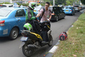 インドネシアのジャカルタで、新興企業Go-Jekのバイクタクシー運転手に運賃を支払う乗客（右、2015年6月11日撮影）。(c)AFP/ADEK BERRY