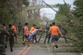 フィリピン北部のカガヤン州バガオで、台風22号（アジア名：マンクット）の強風で倒された電柱などを道路から除去する救助隊員ら（2018年9月15日撮影）。(c)TED ALJIBE / AFP