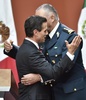 メキシコの首都メキシコ市で、脱獄した麻薬王「エル・チャポ」ことホアキン・グスマン受刑者の身柄拘束を発表し、防衛相と抱き合うエンリケ・ペニャニエト大統領（左、2016年1月8日撮影）。(c)AFP/OMAR TORRES