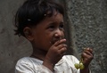 パキスタン・カラチのスラム街で、ハエが群がる中でブドウを食べる子ども（2019年9月2日撮影）。(c)ASIF HASSAN / AFP