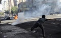 トルコ・ディヤルバクル（Diyarbakir）で、軍の装甲車両に向け投石するクルド人男性（2014年10月8日撮影）。(c)AFP/ILYAS AKENGIN