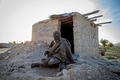 イラン南部ファルス州で、村民が建ててくれたれんがの小屋の前に座るアモウ・ハジさん（2018年12月28日撮影）。(c)AFP