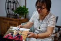 新型コロナウイルス感染症で亡くなった息子の写真を見せる中国・武漢市在住の鍾漢能さん（2020年9月6日撮影）。(c)Hector RETAMAL / AFP