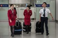 香港の空港に到着したキャセイパシフィック航空（Cathay Pacific Airways）の客室乗務員ら（左2人、2014年5月5日撮影）。(c)AFP/Philippe Lopez