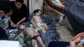 シリア反体制派が掌握していたドゥーマで、化学兵器の使用が疑われる攻撃により負傷した子どもの治療に当たるボランティア。「シリア民間防衛隊」公開の動画より（2018年4月8日撮影、資料写真）。(c)AFP PHOTO / HO / SYRIA CIVIL DEFENCE