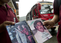 コロンビア・メデジン（Medellin）の貧困地区で、麻薬王パブロ・エスコバル（Pablo Escobar）のシールブックを手にする少年（2012年8月8日撮影）。(c)AFP/Raul ARBOLEDA