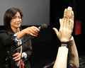 東京・江東区の日本科学未来館（National Museum of Emerging Science and Innovation）で開催中の「デジタルコンテンツエキスポ（Digital Content Expo）」のオープニングで、音楽に合わせて拍手するデモンストレーションをするロボットアーム「音手（おんず）」（右）と、マイクの調整をするスタッフ(2011年10月20日撮影)。(c)AFP/Yoshikazu TSUNO