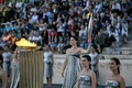 ギリシャ・アテネのパナシナイコ・スタジアムで行われたパリ五輪の聖火引継ぎ式で、聖火トーチを掲げる同国の俳優マリー・ミナさん（中央奥、2024年4月26日撮影）。(c)Aris MESSINIS / AFP