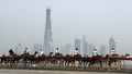 2007年４月2日、ドバイ（Dubai）で建設中の超高層ビル｢ブルジュ・ドバイ（Burj Dubai）｣の前を通るラクダのキャラバン。(c)AFP/KARIM SAHIB