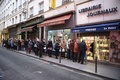 フランス・パリ（Paris）市内にある新聞の販売店で、風刺週刊紙シャルリー・エブド（Charlie Hebdo）の本社襲撃事件後初となる最新号の発売に合わせて列を作る客（2015年1月14日撮影）。(c)AFP/MARTIN BUREAU
