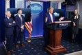 米ホワイトハウスで、新型コロナウイルス関連の定例記者会見で発言するドナルド・トランプ大統領と、それを見つめるアンソニー・ファウチ国立アレルギー感染症研究所所長（左）ら（2020年4月1日撮影）。(c)MANDEL NGAN / AFP
