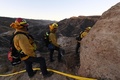 米カリフォルニア州サンタクラリタ付近で、防火線を設置するため峡谷を登る消防隊（2019年10月25日撮影）。(c)Mark RALSTON / AFP