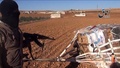 シリア北部の町アインアルアラブ（Ain al-Arab、クルド名：コバニ、Kobane）近郊で、パラシュート付きの箱を指し示すイスラム過激派組織「イスラム国（Islamic State、IS）」の戦闘員を撮影したとされる動画のひとこま。イスラム国制圧地域からの映像を投稿するユーチューブ（YouTube）チャンネル「Aamaq News」より（2014年10月21日公開）。(c)AFP/HO/AAMAQ NEWS