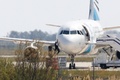 キプロス・ラルナカのラルナカ国際空港で、エジプト航空のエアバスA320型機の操縦室の窓から脱出する男性（2016年3月29日撮影）。(c)AFP/BEHROUZ MEHRI