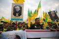 イラクの首都バグダッドで、イラン革命防衛隊のガセム・ソレイマニ司令官と人民動員隊のアブ・マフディ・ムハンディス副司令官の葬列に加わった、人民動員隊や親イラン派武装組織「神の党旅団（カタイブ・ヒズボラ）」の支持者ら（2020年1月4日撮影）。(c)AFP/Ahmad AL-RUBAYE