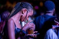 ウガンダ南東部ジンジャのイタンダ滝で開かれた音楽フェス「ニゲニゲ」で、飲み物を飲みながらスマートフォンを見る観客（2022年9月16日撮影）。(c)BADRU KATUMBA / AFP