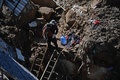 ブラジル・ペトロポリスで発生した土砂災害の現場で、犬を救助する憲兵（2022年2月17日撮影）。(c)CARL DE SOUZA / AFP
