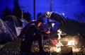 雨の中、たき火で料理する男性。(c)AFP/Bulent Kilic