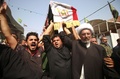 イラク南部バスラで営まれたイスラム教シーア派系民兵組織「人民動員隊」のベテラン狙撃手アブ・タフシン・サルヒ氏の葬儀でサルヒ氏のひつぎを運ぶ参列者ら（2017年9月30日撮影）。(c)AFP/HAIDAR MOHAMMED ALIALI