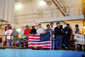 ケニア・モンバサ（Mombasa）港に停泊中の米船籍の貨物船マースク・アラバマ（Maersk Alabama ）号の甲板から報道関係者と話している最中にリチャード・フィリップス（Richard Phillips）船長が海賊から救出されたとのニュースを聞き米国旗を振って喜ぶ乗組員たち（2009年4月12日撮影）。(c)AFP/Roberto SCHMIDT