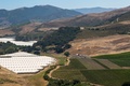 米カリフォルニア州カーピンテリアで、ブドウ園（右）の横につくられた大麻栽培温室（2019年8月6日撮影）。(c)DAVID MCNEW / AFP