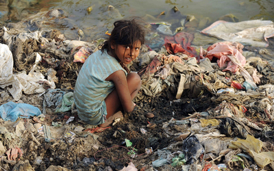 インドの川岸で小銭を探す子ども