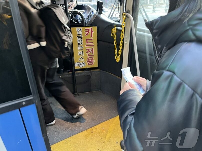 「現金は使えない」とバスに乗車を拒否された落合さん。2000ウォンを握りしめていた(c)news1