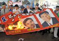 韓国ソウル（Seoul）の金浦空港（Gimpo airport）で、自民党の新藤義孝（Yoshitaka Shindo）衆院議員、稲田朋美（Tomomi Inada）衆院議員、佐藤正久（Masahisa Sato）参院議員の写真を燃やして3人の鬱陵島訪問計画に抗議する活動家ら（2011年8月1日撮影）。(c)AFP/JUNG YEON-JE