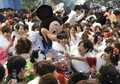 成人の日の9日、千葉県浦安（Urayasu）市の成人式が東京ディズニーランド（Tokyo Disneyland）で開かれた。政府統計によると、1日現在20歳の新成人の人口は122万人で、最も多かった1970年の246万人の半数を初めて割り込んだ。

写真は、ミッキーマウスから祝福されて大喜びの晴れ着姿の新成人たち（2012年1月9日撮影）。(c)AFP/ KAZUHIRO NOGI
