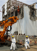 東京電力（TEPCO）は26日、福島第1原子力発電所の敷地内を報道陣に公開した。写真は第1原発4号機のそばを歩く報道陣と東電従業員（2012年5月26日撮影）。(c)AFP/POOL/Tomohiro Ohsumi
