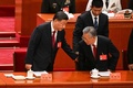中国・北京の人民大会堂で行われた中国共産党第20回大会開幕式で、習近平国家主席（左）の介添えを受けて席に着く胡錦濤前国家主席（2022年10月16日撮影）。(c)Noel CELIS / AFP