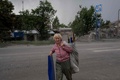 ロシア軍の攻撃で破壊された建物の残骸を運ぶ住民。ウクライナ東部ドネツク州トレツクで（2022年8月5日撮影）。(c)Bulent KILIC / AFP