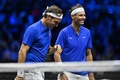 男子テニスの欧州チームとワールドチームの対抗戦、レーバー・カップ初日。試合中に笑い合う欧州チームのロジャー・フェデラー（左）/ラファエル・ナダル組（2022年9月23日撮影）。(c)Glyn KIRK / AFP