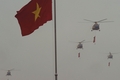 ベトナム・ハノイ（Hanoi）で行われた軍事パレードで、ベトナム国旗と共産主義の旗を引いて、ホーチミン廟の上空を飛行するヘリコプター（2010年10月10日撮影）。(c)AFP/HOANG DINH Nam