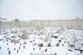 スペイン・マドリード市内の王宮前で雪を楽しむ人々（2021年1月9日撮影）。(c)Gabriel BOUYS / AFP
