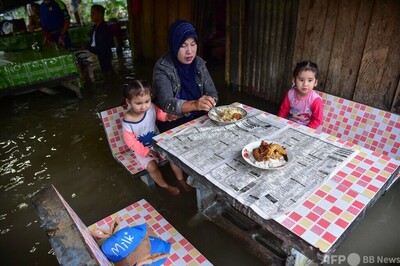 水に漬かりながら食事も タイ南部で洪水