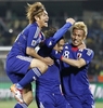 2010年サッカーW杯南アフリカ大会（%%2010 World Cup%%）1次リーグE組、デンマーク対日本。日本は3-1で勝利し、勝ち点6（2勝1敗）の同組2位で決勝トーナメントに進んだ。日本の決勝トーナメント進出は、自国開催以外のW杯では初めて。写真は前半30分にチームの2点目を決め、本田圭佑（%%Keisuke Honda%%、右）と大久保嘉人（%%Yoshito Okubo%%、左）から祝福される日本の遠藤保仁（%%Yasuhito Endo%%、中央）。（2010年6月24日撮影）(c)AFP/THOMAS COEX