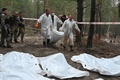 ウクライナ・イジューム近郊の森で見つかった遺体を搬送する科学捜査班（2022年9月16日撮影）。(c)SERGEY BOBOK / AFP