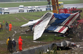 2007年9月17日、プーケット国際空港で着陸に失敗し炎上したタイ航空会社ワンツーゴー（One-Two-Go）旅客機の尾翼部分を重機で移動させる作業員たち。(c)AFP